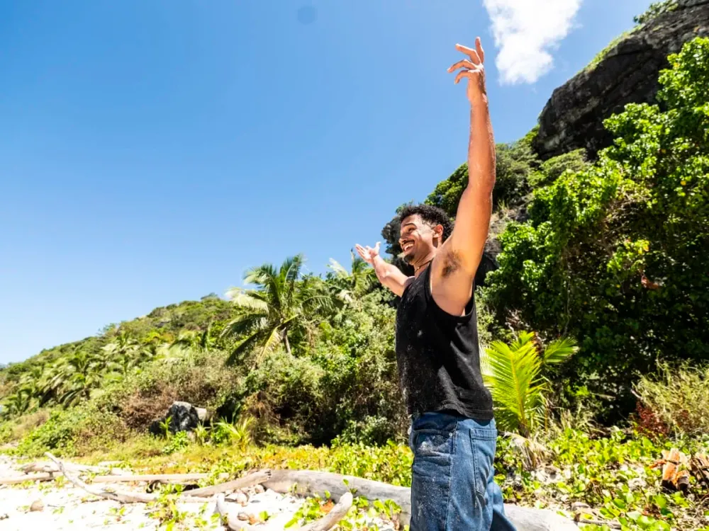 Devin Way raising an arm on the beach on Day 1 of Survivor 51