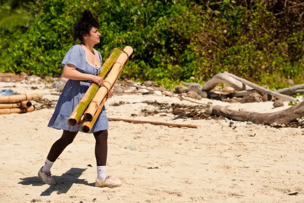 Ana Sani carrying bamboo on the beach on Day 1 of Survivor 51