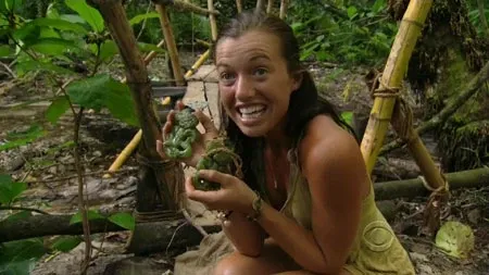 Parvati Shallow grinning in the jungle with two hidden immunity idols in her hands
